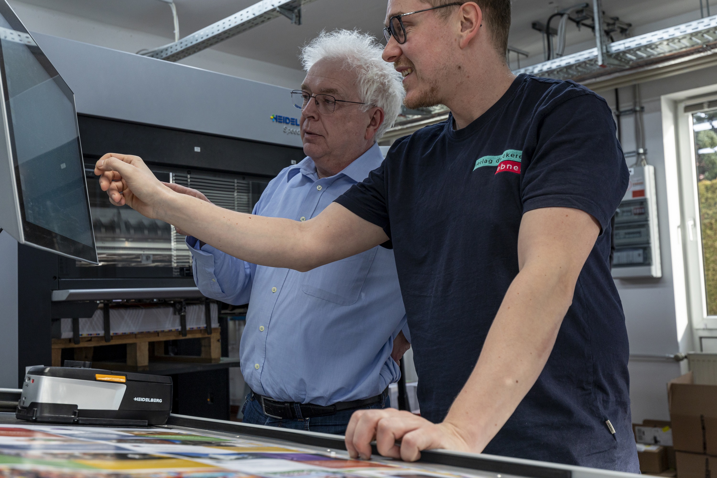 Bernd Utter (jefe de producto de HEIDELBERG) y Jürgen Sporrer (de izda. a dcha.) dialogando junto al sistema de medición del color Prinect Easy Control.